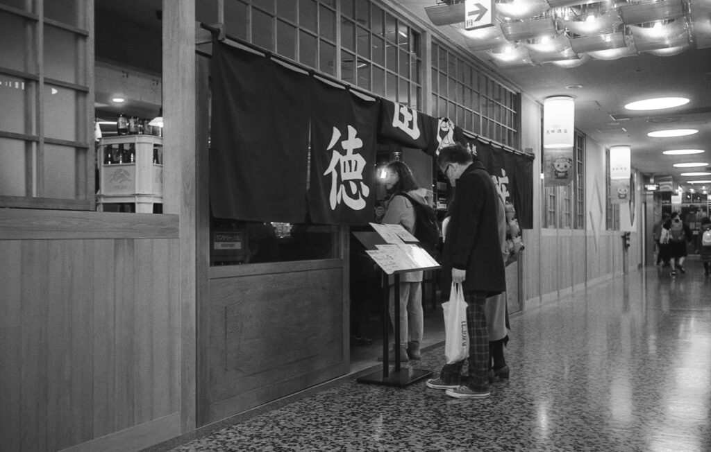 交通会館の徳田酒店がなかなかの賑わい|Leica M3 + Summaron 35mm F3.5 with goggles + Fomapan 400 Action
